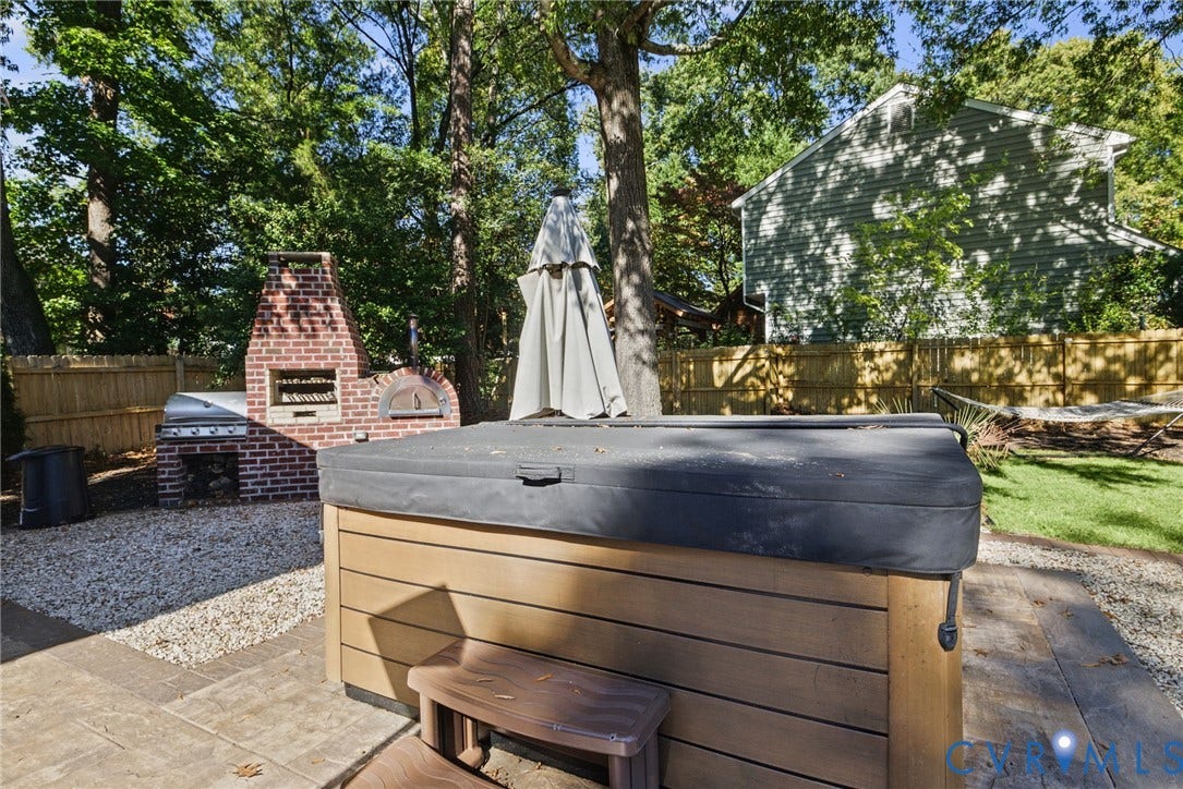 4504 Argonne Court, Glen Allen, VA 23060 Outdoor space featuring a built-in brick fireplace and pizza oven, integrated spa, and stamped concrete patio surfacing