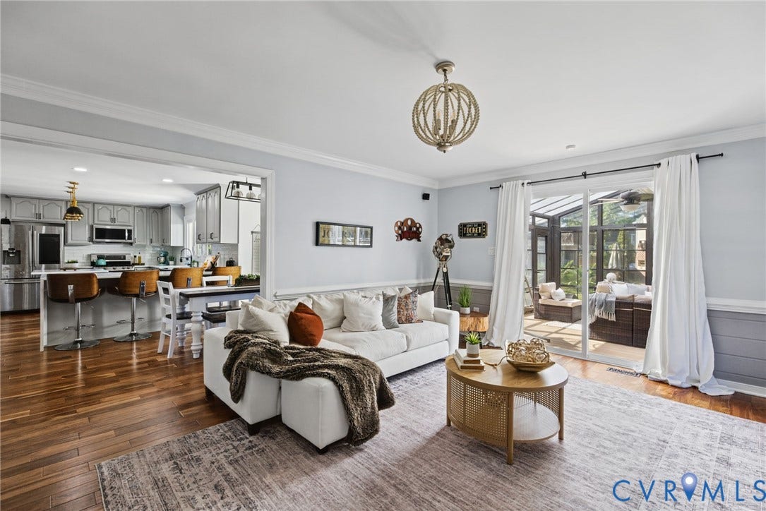 4504 Argonne Court, Glen Allen, VA 23060 Open-concept interior featuring wood-finish flooring, crown molding, chair rail trim, a multi-light spherical chandelier, and sliding glass doors