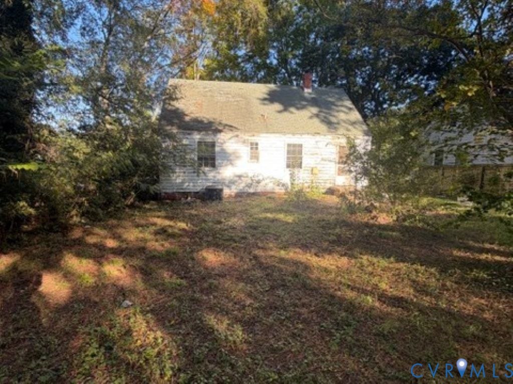 1330 Devers Road, Henrico, VA 23226 Single-story residence featuring a gabled roof, masonry chimney, and light-colored siding, situated on a lot with mature trees