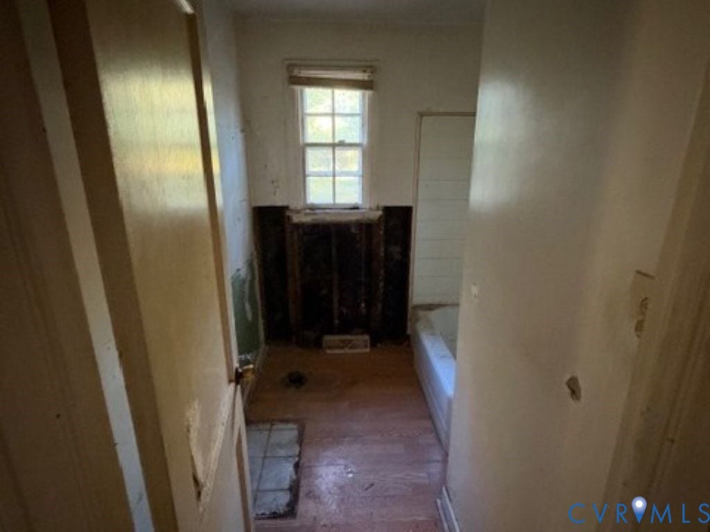 1330 Devers Road, Henrico, VA 23226 Single-pane sash window with integrated muntins, wood-finish flooring, and a standard-size bathtub enclosure