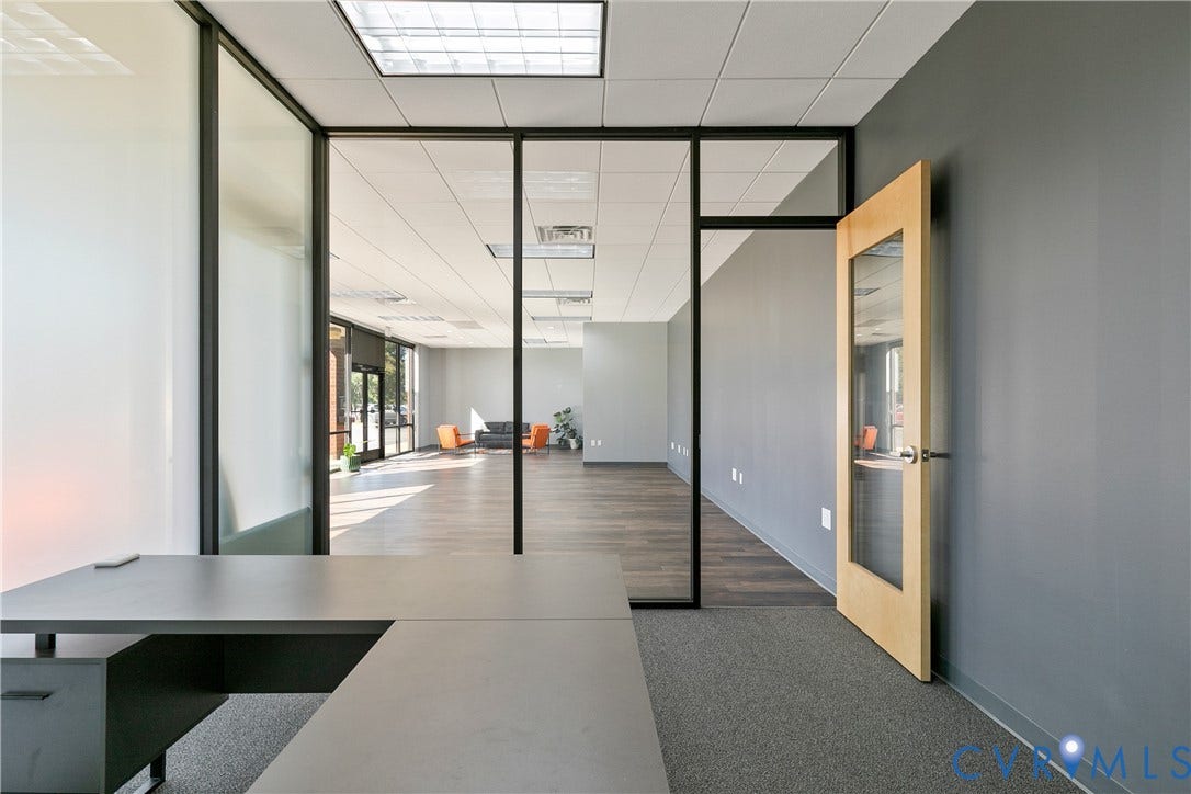 2575 Homeview Drive, Richmond, VA 23294 Interior office space featuring black-framed glass partitions, wood-finish flooring, a light-wood door with an inset glass panel, and recessed grid ceiling lighting
