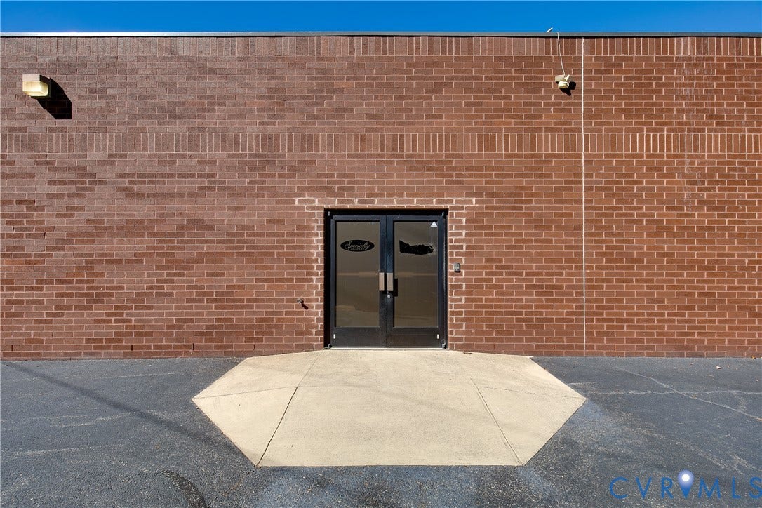 2575 Homeview Drive, Richmond, VA 23294 Exterior facade featuring a durable brick masonry wall, double glass entry doors with aluminum frames, and a concrete landing pad