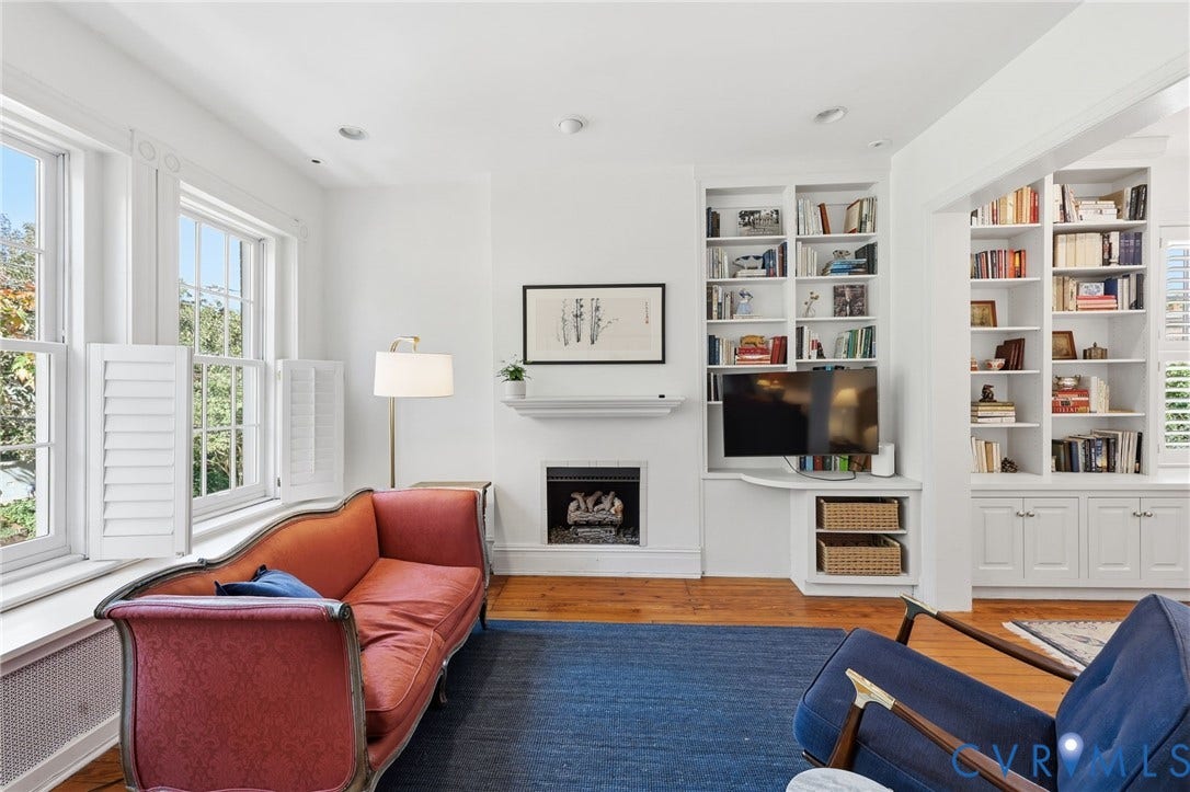 107 N Harvie Street, The Fan, Richmond, VA 23220 Fireplace with a mantel, built-in floor-to-ceiling shelving, wood-finish flooring, and multi-pane windows with plantation-style shutters