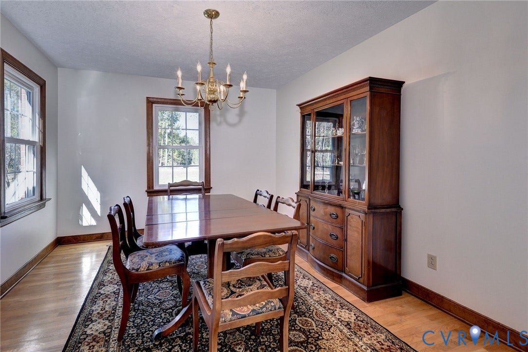 14151 Black Horse Lane, Lanexa, VA 23089 Dining area featuring wood-finish flooring, multi-pane windows with wood trim, and a multi-arm metallic chandelier