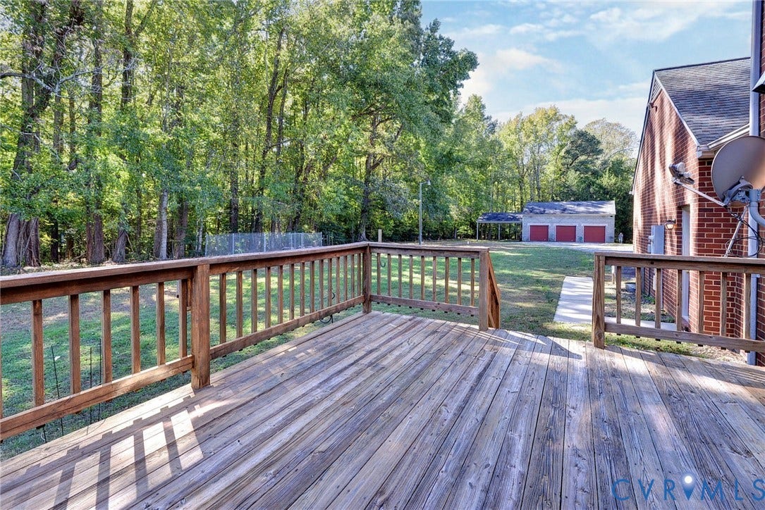 14151 Black Horse Lane, Lanexa, VA 23089 Elevated wooden deck with railings, brick exterior, sprawling grounds, mature trees, and detached three-car garage