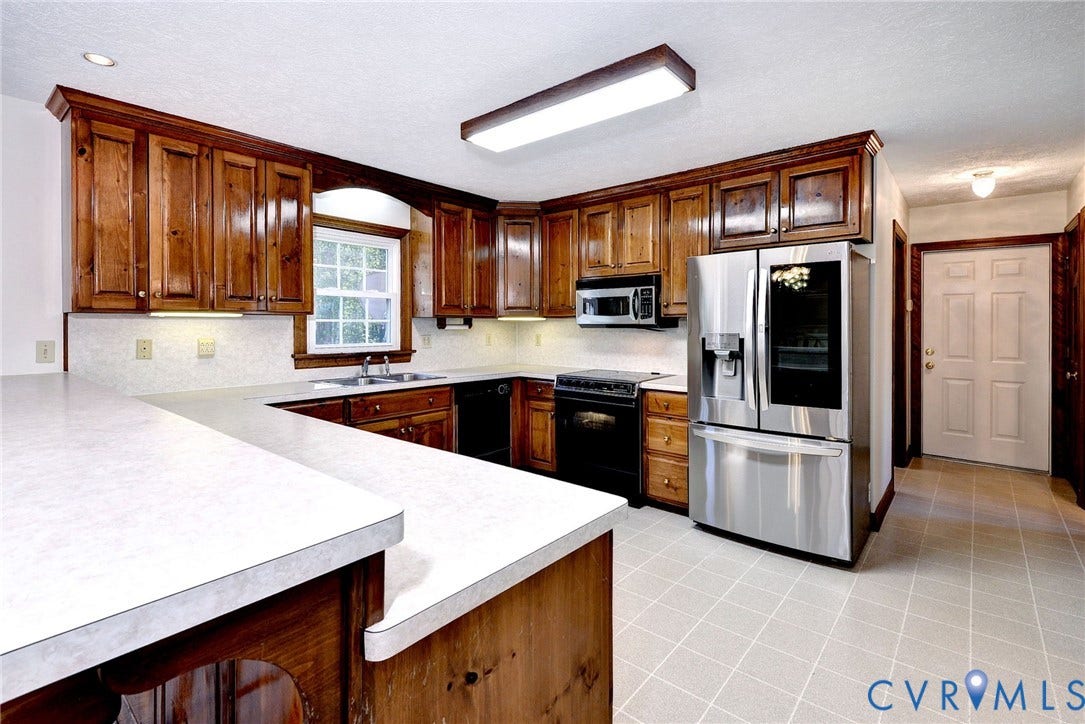 14151 Black Horse Lane, Lanexa, VA 23089 Kitchen featuring stained wood cabinetry, extended countertops, stainless steel appliances, and tiled flooring