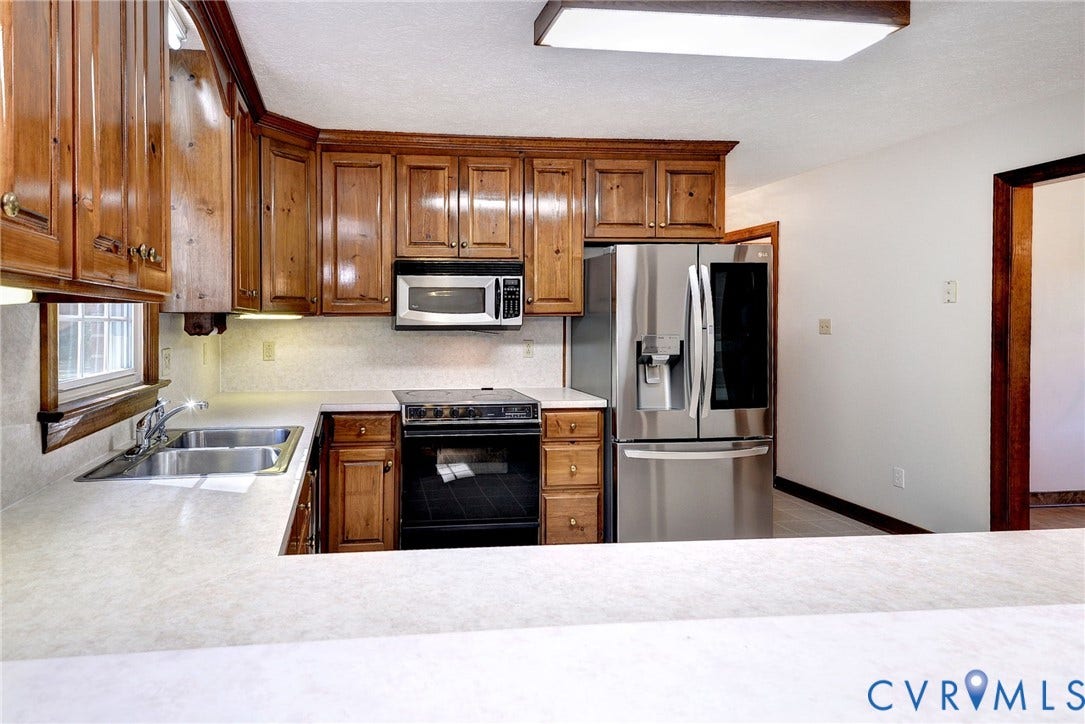 14151 Black Horse Lane, Lanexa, VA 23089 Kitchen featuring solid wood cabinetry, stainless steel refrigerator, built-in microwave, integrated electric range, and laminate countertops