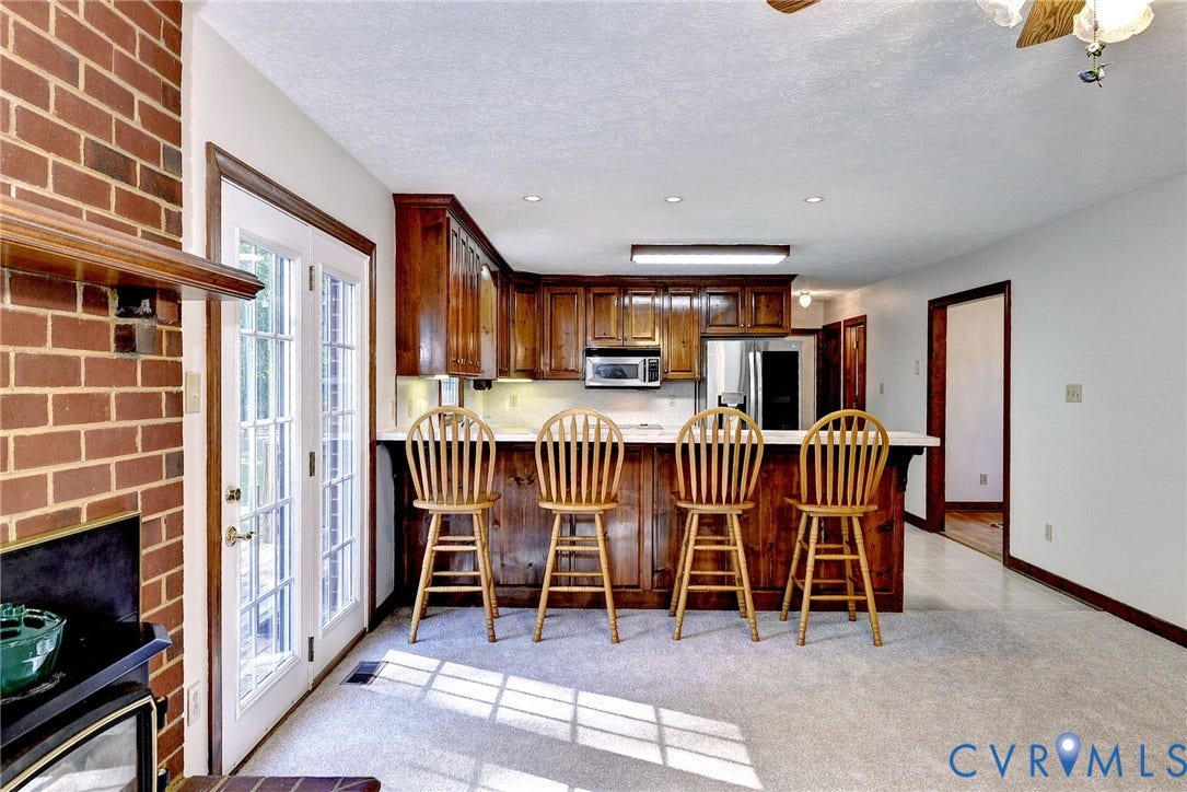 14151 Black Horse Lane, Lanexa, VA 23089 Kitchen featuring wood cabinetry, breakfast bar with countertop seating, recessed lighting, and glass-paned doors leading to exterior