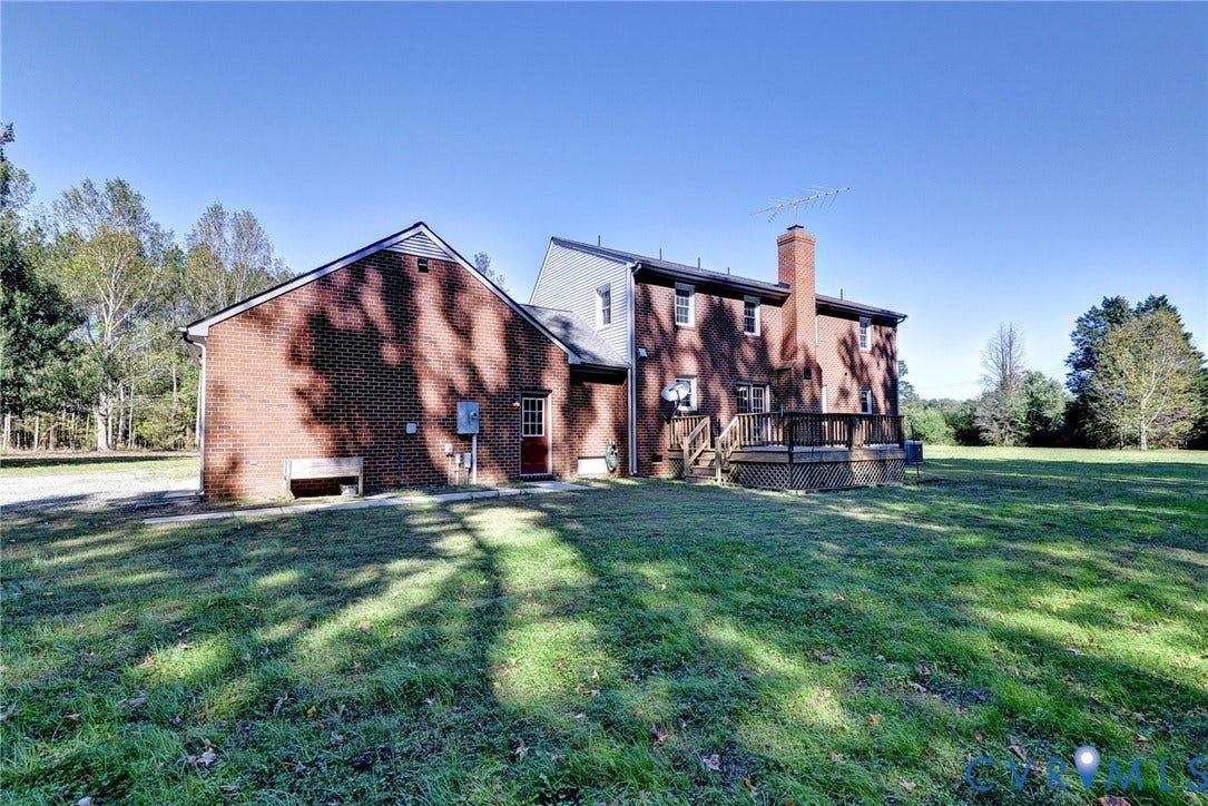 14151 Black Horse Lane, Lanexa, VA 23089 Brick exterior featuring a masonry chimney, elevated wooden deck, and expansive grass acreage