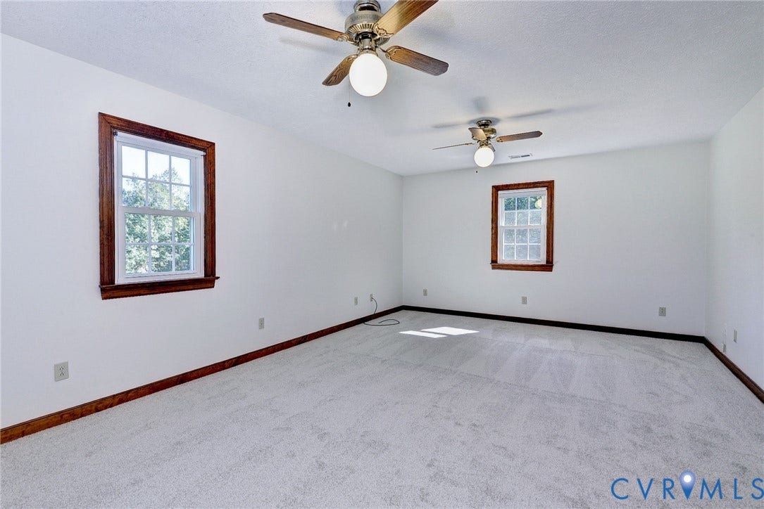 14151 Black Horse Lane, Lanexa, VA 23089 Interior space featuring wall-to-wall carpeting, dual ceiling fans with integrated lighting, and multi-pane windows framed by dark wood trim