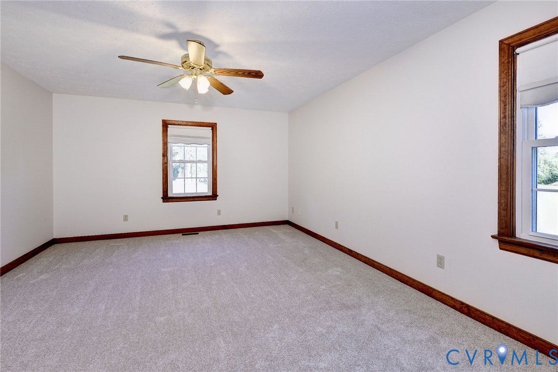 14151 Black Horse Lane, Lanexa, VA 23089 Neutral wall-to-wall carpeting, wood-trimmed window casings, and a ceiling-mounted light fixture with a multi-blade fan