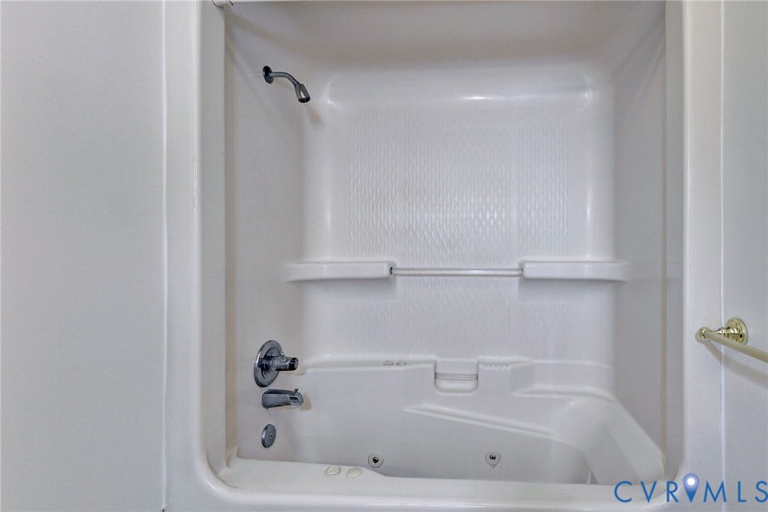 14151 Black Horse Lane, Lanexa, VA 23089 Recessed tub and shower combination featuring molded shelving, integrated jetted tub system, and metallic plumbing fixtures