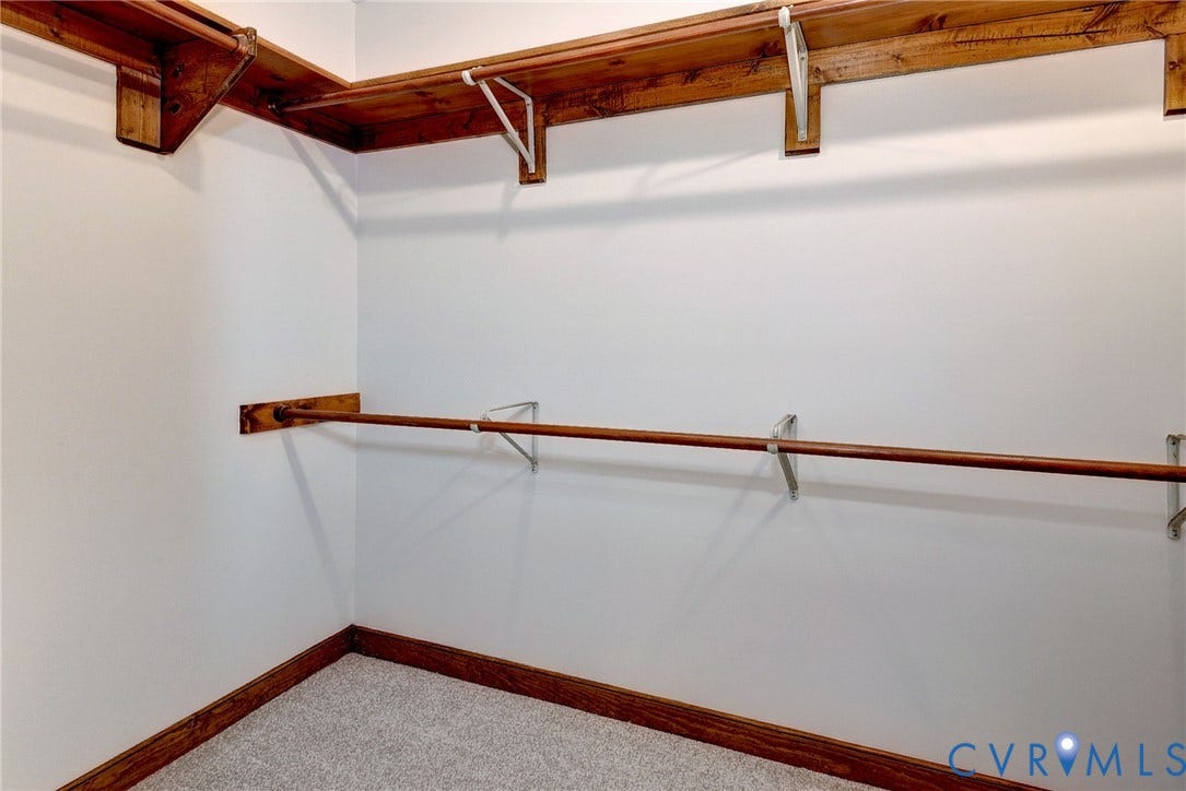 14151 Black Horse Lane, Lanexa, VA 23089 Walk-in storage space featuring wood shelving, integrated hanging rods, and neutral carpeting