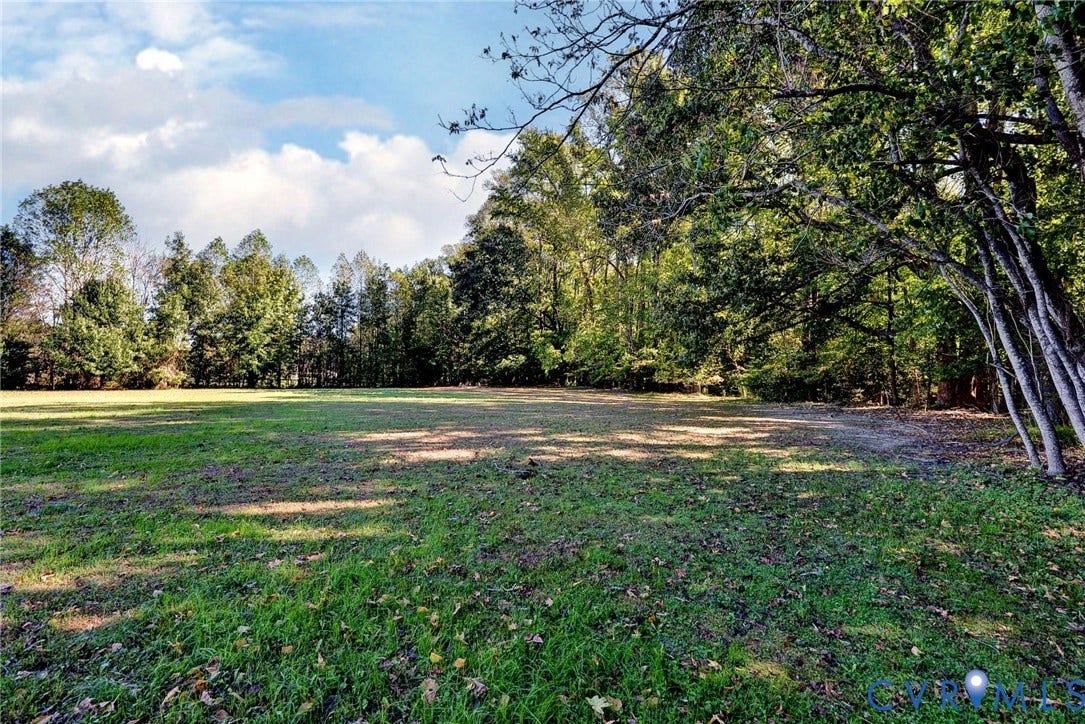 14151 Black Horse Lane, Lanexa, VA 23089 Expansive open lot featuring level terrain, cleared grassy areas, and mature tree borders
