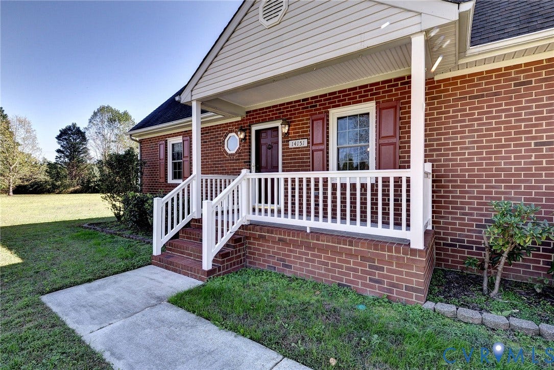 14151 Black Horse Lane, Lanexa, VA 23089 Traditional brick exterior featuring a covered front porch with white railing, vinyl siding gable, and decorative shutters