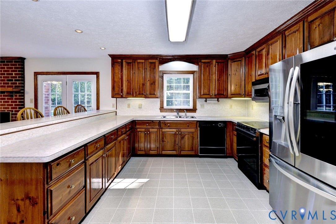 14151 Black Horse Lane, Lanexa, VA 23089 Kitchen featuring stained wood cabinetry, solid-surface countertops, tile flooring, stainless steel refrigerator, and integrated appliances