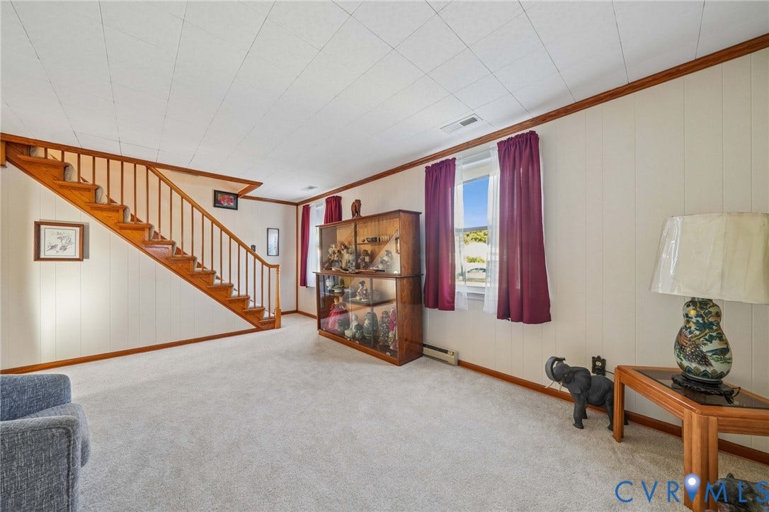 3030 Brentwood Circle, Chesterfield, VA 23237 Open-concept space featuring wall-to-wall carpeting, wood-finish staircase with vertical balusters, and windows with wood-trim molding