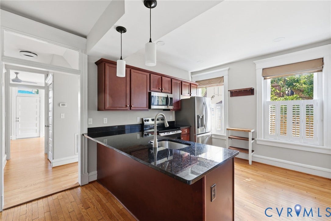 101 N Stafford Avenue, #U4, Stafford Terrace Condo, Richmond, VA 23220 Kitchen featuring dark-toned cabinetry, a peninsula with a stone-finish countertop, stainless steel appliances, wood-finish flooring, and dual pendant lighting