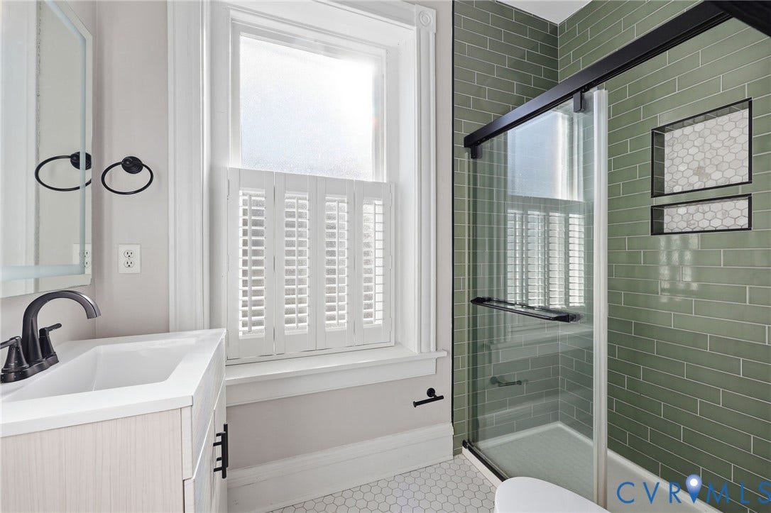 101 N Stafford Avenue, #U4, Stafford Terrace Condo, Richmond, VA 23220 Bathroom featuring sage green subway tile shower surround with dual inset niches, glass enclosure with matte black hardware, white hexagonal tile flooring, and light wood-finish vanity