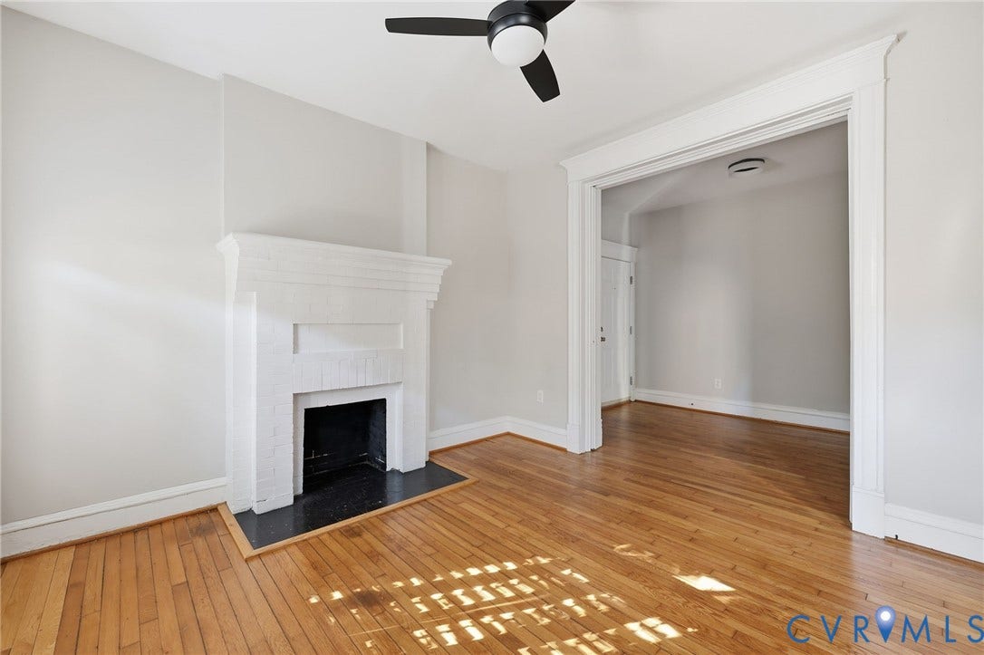 101 N Stafford Avenue, #U4, Stafford Terrace Condo, Richmond, VA 23220 Painted brick fireplace with a dark hearth, wood-finish flooring, ceiling fan, and wide architectural cased opening