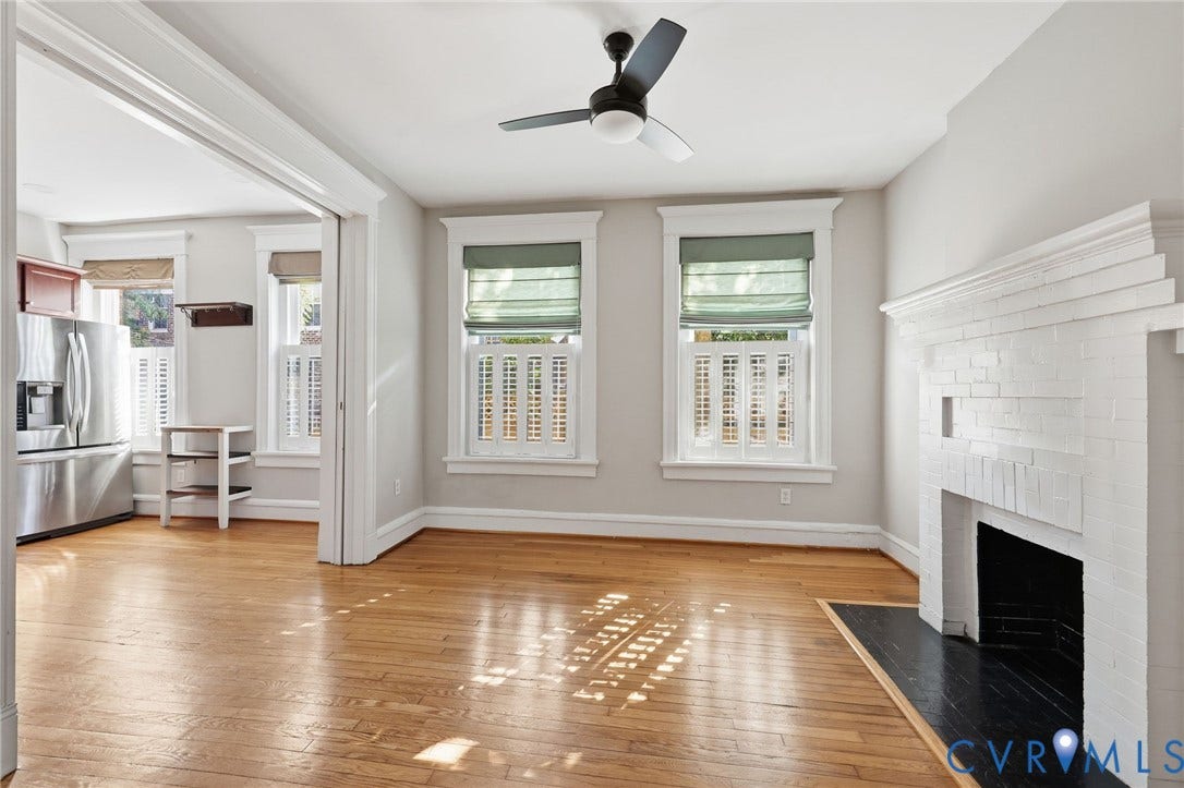 101 N Stafford Avenue, #U4, Stafford Terrace Condo, Richmond, VA 23220 Interior space featuring wood-finish flooring, a painted brick fireplace with a contrasting hearth, multi-pane windows with traditional millwork, and a ceiling-mounted light fixture with a fan