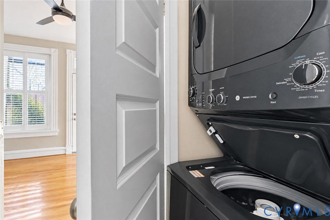 101 N Stafford Avenue, #U4, Stafford Terrace Condo, Richmond, VA 23220 Stacked black laundry appliance with top-loading washer, wood-finish flooring, and white paneled door