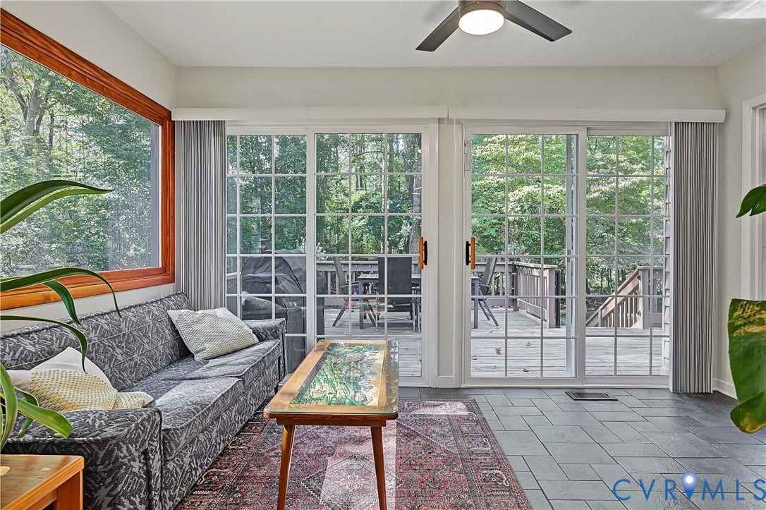 3800 Pheasant Hollow Drive, Henrico, VA 23231 Sunroom featuring grid-pattern sliding glass doors, natural wood window trim, slate-finish tile flooring, and a ceiling fan with integrated lighting