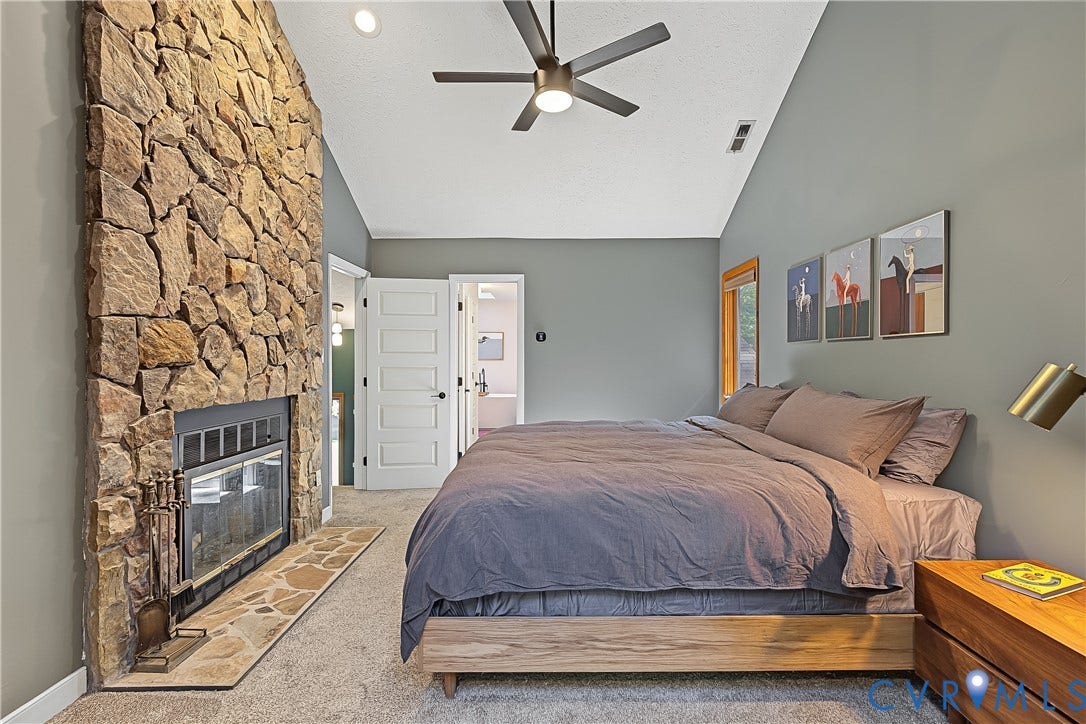 3800 Pheasant Hollow Drive, Henrico, VA 23231 Floor-to-ceiling stone fireplace with a stone hearth, vaulted ceilings, and a ceiling fan