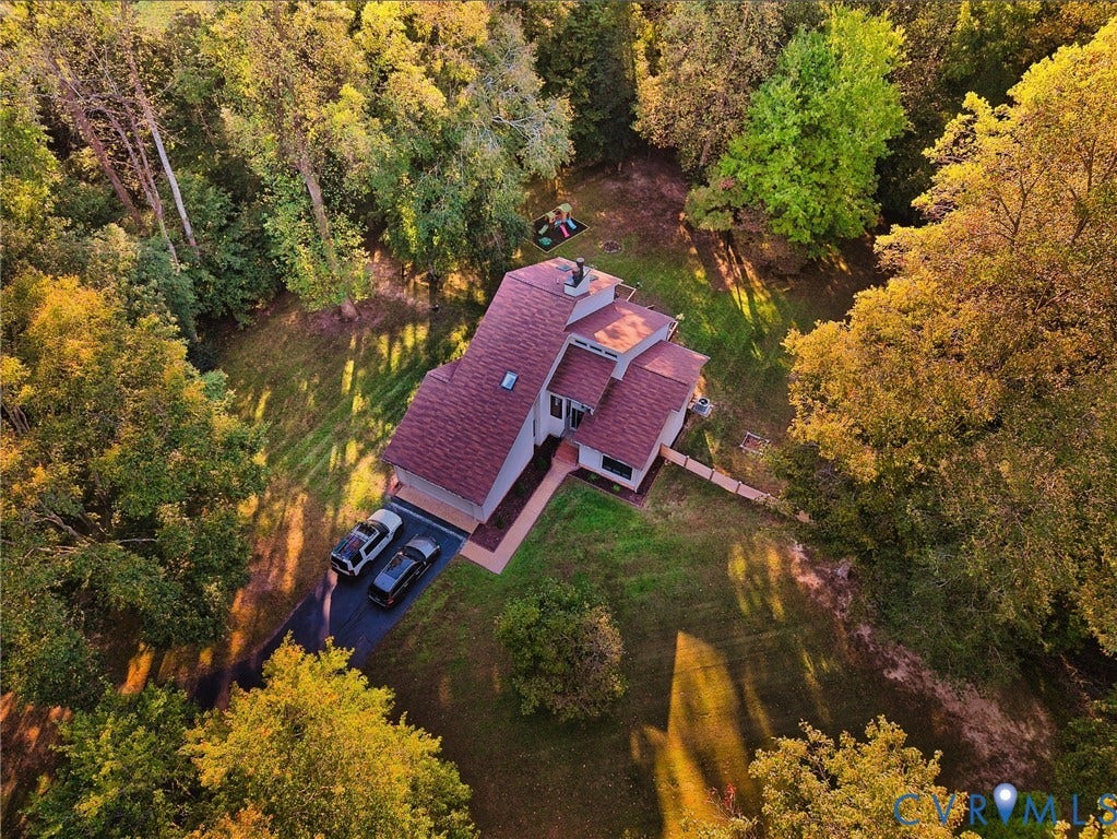 3800 Pheasant Hollow Drive, Henrico, VA 23231 Aerial view of a multi-level residence featuring a pitched roof, an asphalt driveway, and expansive, wooded grounds with mature trees