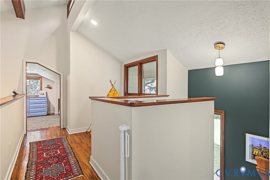 3800 Pheasant Hollow Drive, Henrico, VA 23231 Vaulted ceilings featuring exposed wood beam, hardwood flooring, dual-tone wall treatment, and modern pendant lighting