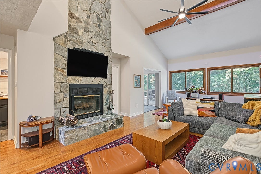 3800 Pheasant Hollow Drive, Henrico, VA 23231 Vaulted ceilings with exposed wood beams, floor-to-ceiling stone fireplace, wood-finish flooring, and expansive windows