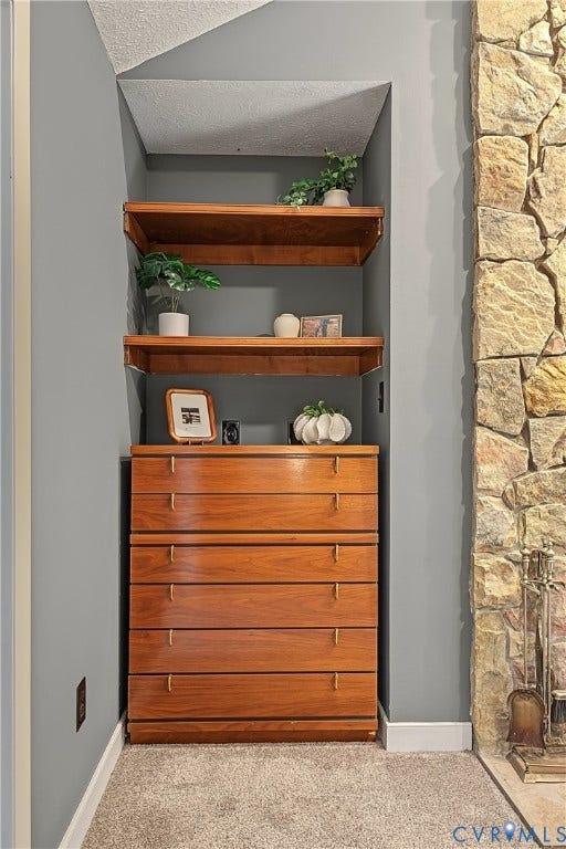 3800 Pheasant Hollow Drive, Henrico, VA 23231 Built-in wood cabinetry featuring a six-drawer dresser and dual open shelving, complemented by a floor-to-ceiling natural stone fireplace surround
