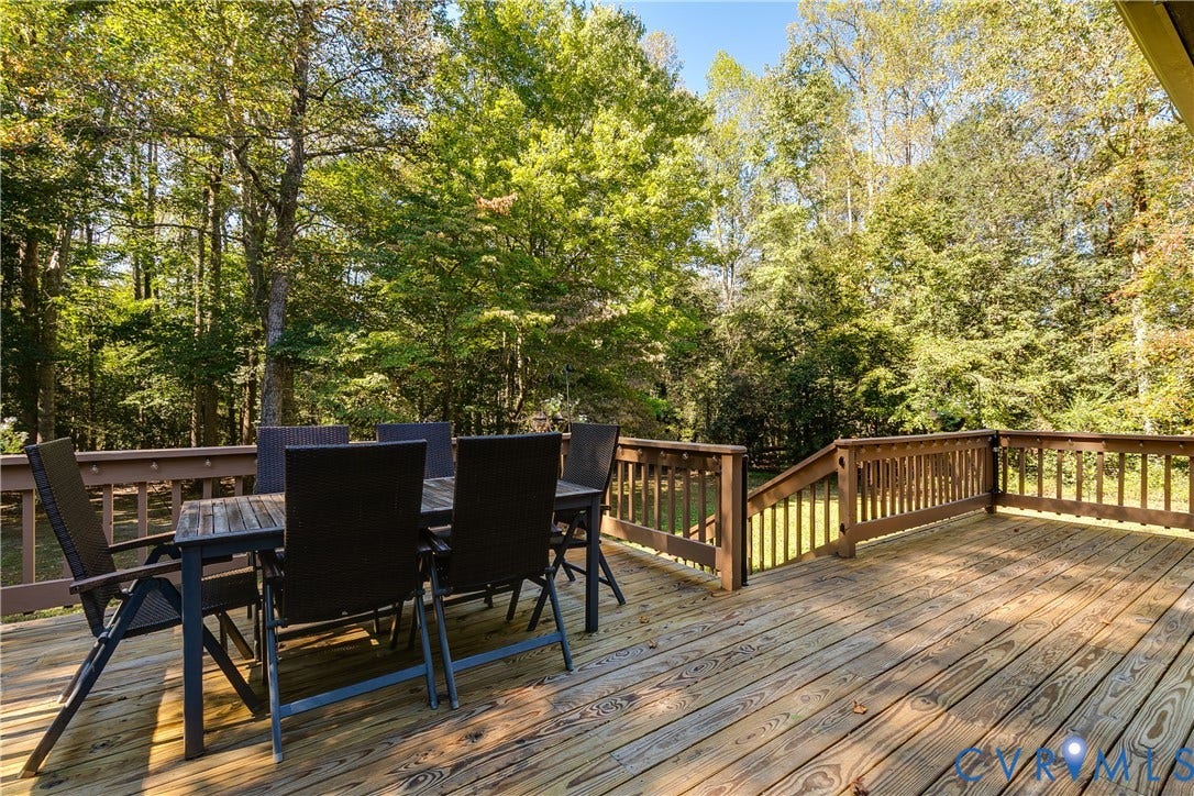3800 Pheasant Hollow Drive, Henrico, VA 23231 Expansive wood-plank deck featuring a wooden railing and a staircase leading to the rear grounds, framed by mature trees