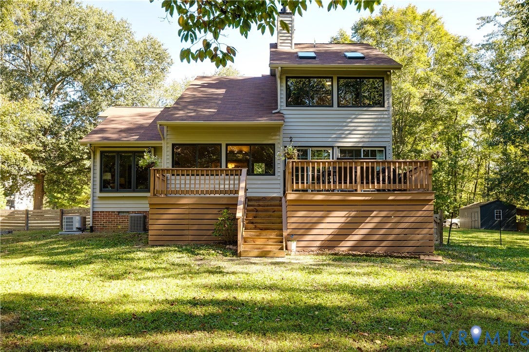 3800 Pheasant Hollow Drive, Henrico, VA 23231 Rear exterior featuring a multi-level wood deck with stairs, a brick and siding facade, skylights, and dark-framed windows