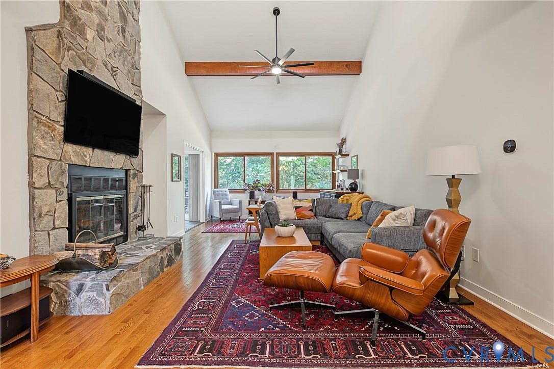 3800 Pheasant Hollow Drive, Henrico, VA 23231 Floor-to-ceiling stone fireplace, vaulted ceilings, exposed wooden ceiling beam, wood-finish flooring, and expansive windows
