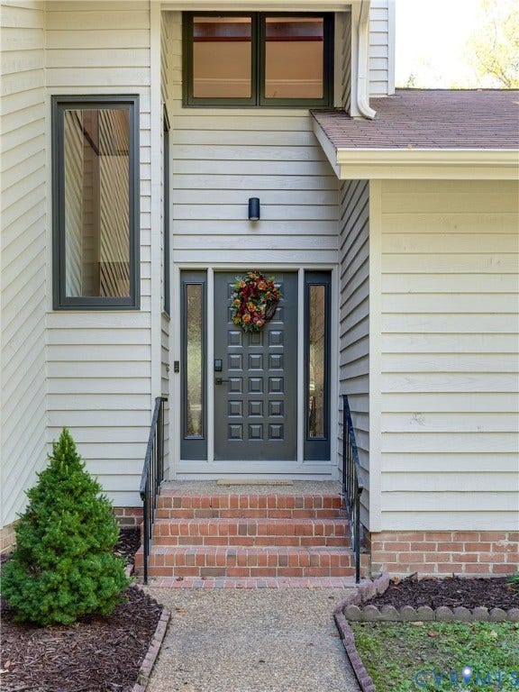 3800 Pheasant Hollow Drive, Henrico, VA 23231 Entryway featuring horizontal siding, brick staircase with metal handrails, paneled door with glass sidelights, and multi-level windows with dark framing