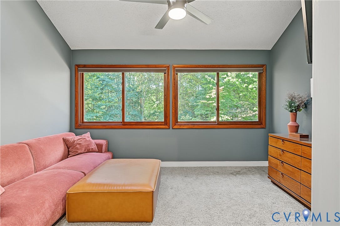 3800 Pheasant Hollow Drive, Henrico, VA 23231 Vaulted ceiling featuring a central lighted ceiling fan, dual windows framed in natural wood, and wall-to-wall carpeting
