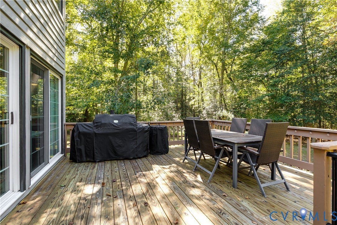 3800 Pheasant Hollow Drive, Henrico, VA 23231 Elevated wooden deck featuring horizontal railings and direct access via sliding glass doors, bordered by mature trees
