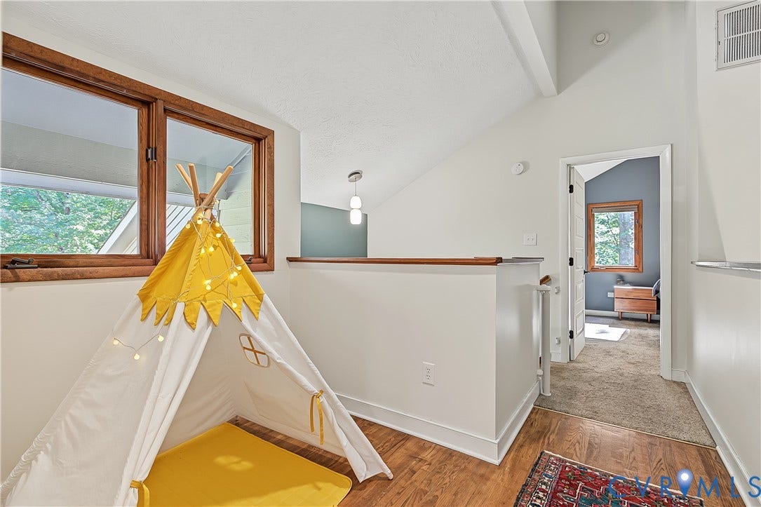3800 Pheasant Hollow Drive, Henrico, VA 23231 Vaulted ceiling with wood-framed windows, wood-finish flooring, and a half-wall partition with a wood cap