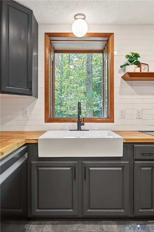 3800 Pheasant Hollow Drive, Henrico, VA 23231 Kitchen featuring a white farmhouse apron-front sink, wood-finish countertops, subway tile backsplash, dark-finished cabinetry, and a globe-style flush mount light fixture