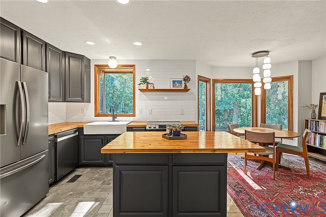 3800 Pheasant Hollow Drive, Henrico, VA 23231 Kitchen featuring dark cabinetry, butcher block countertops, white subway tile backsplash, farmhouse-style apron sink, and a central kitchen island