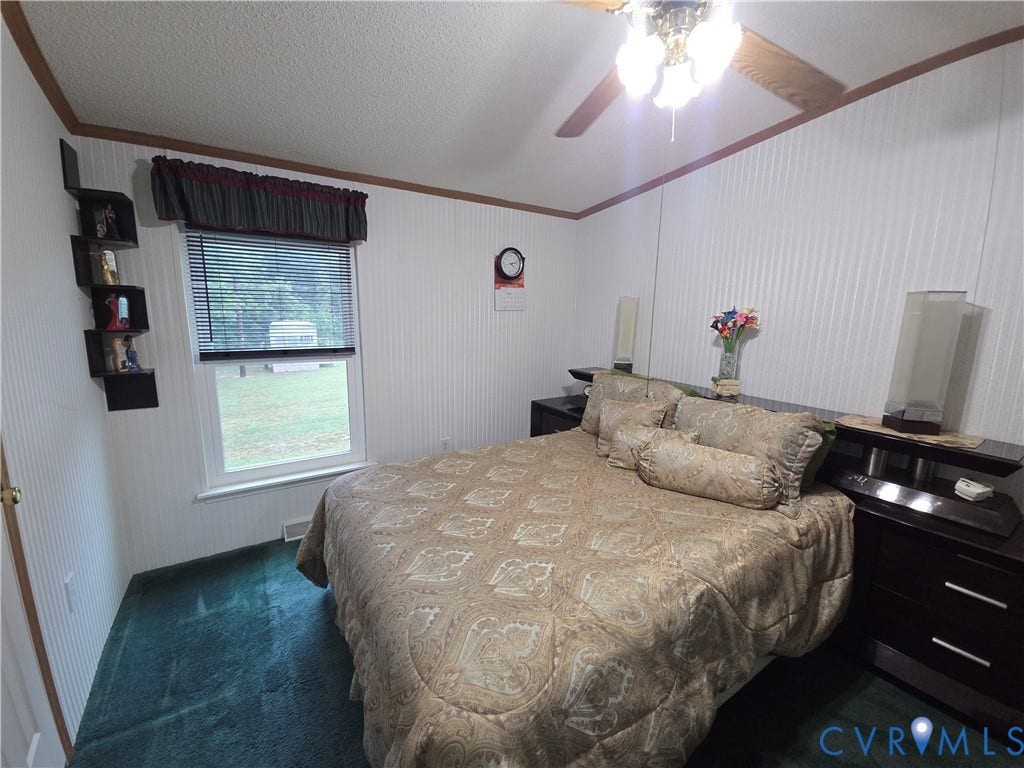 195 Concord Lane, Emporia, VA 23847 Vertical wood-paneled walls, carpeted flooring, and a ceiling fan with integrated light fixture