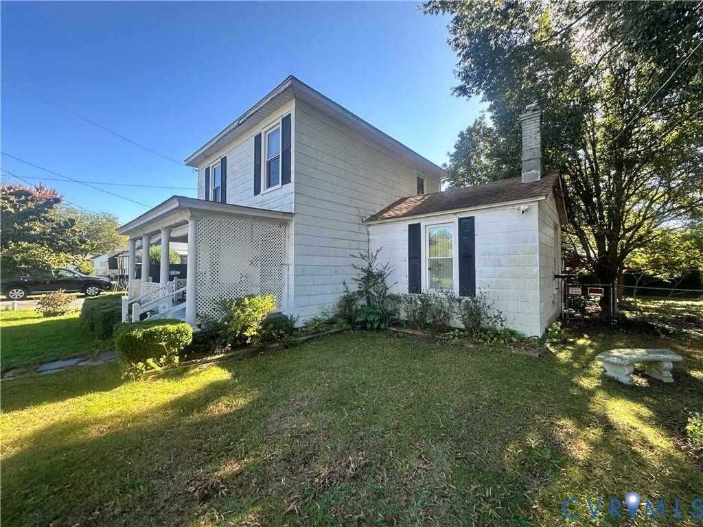 5 N Daisy Avenue, Henrico, VA 23075 Two-story exterior featuring light-colored siding, a covered front porch with latticework, dark-toned window shutters, and a masonry chimney