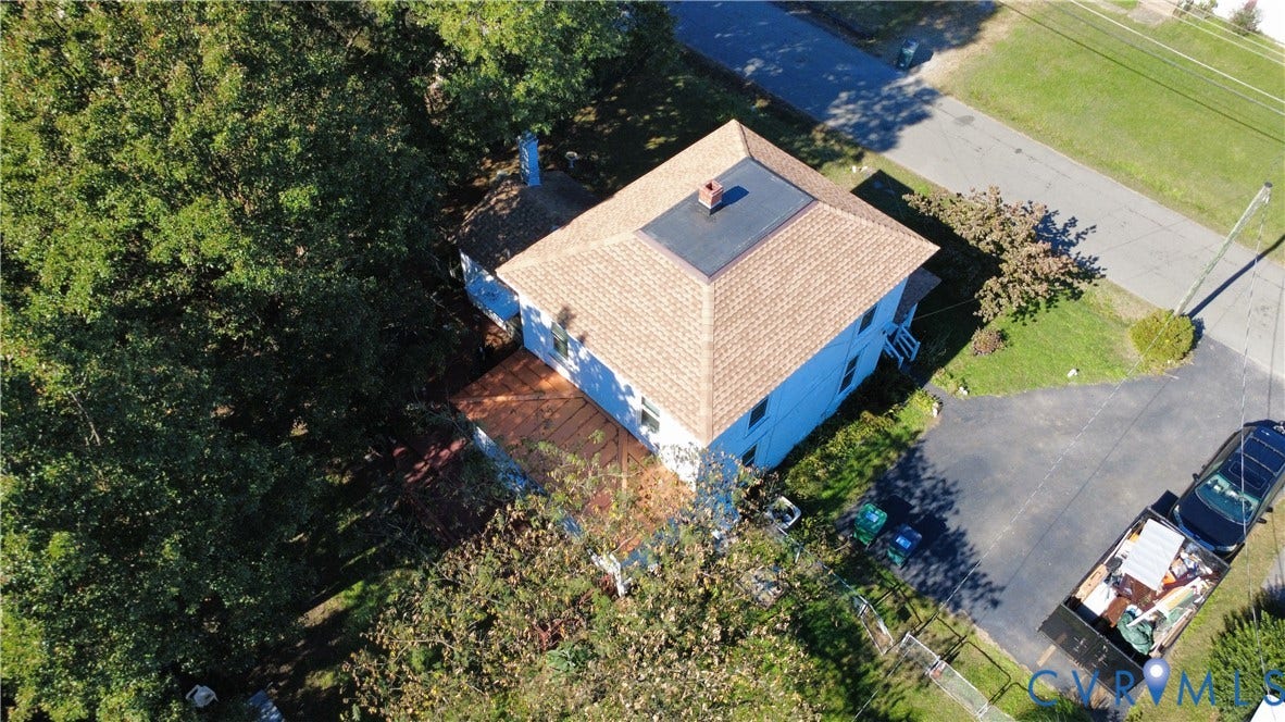 5 N Daisy Avenue, Henrico, VA 23075 Aerial perspective of a detached residence featuring a hip roof with asphalt shingles, a flat roof section, a chimney, and a multi-level deck