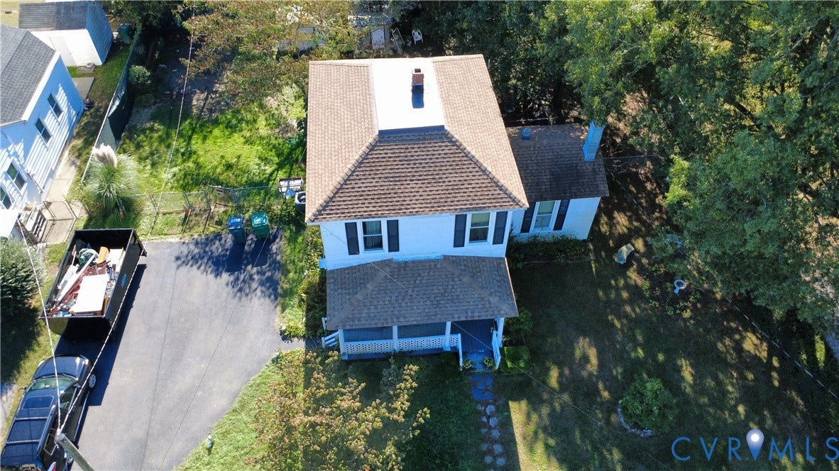 5 N Daisy Avenue, Henrico, VA 23075 Aerial view of a detached residence featuring a shingled hipped roof, covered front porch, paved driveway, and mature landscaping on the grounds