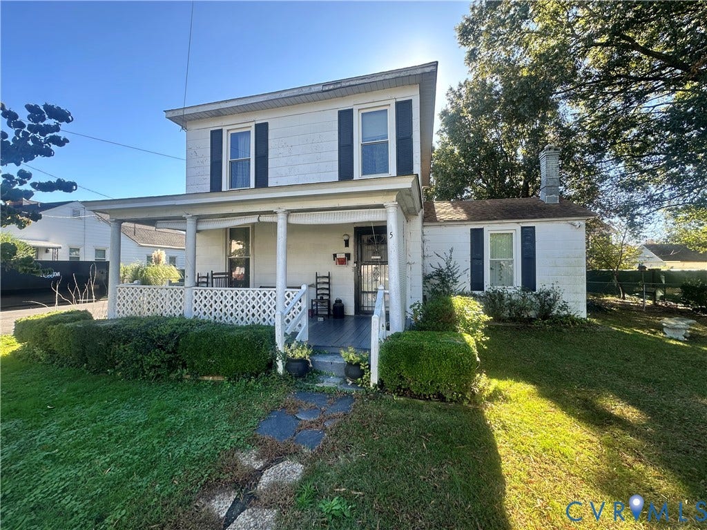 5 N Daisy Avenue, Henrico, VA 23075 Two-story exterior featuring light-colored siding, a full-width covered front porch with lattice railing, dark decorative shutters, and an attached masonry chimney