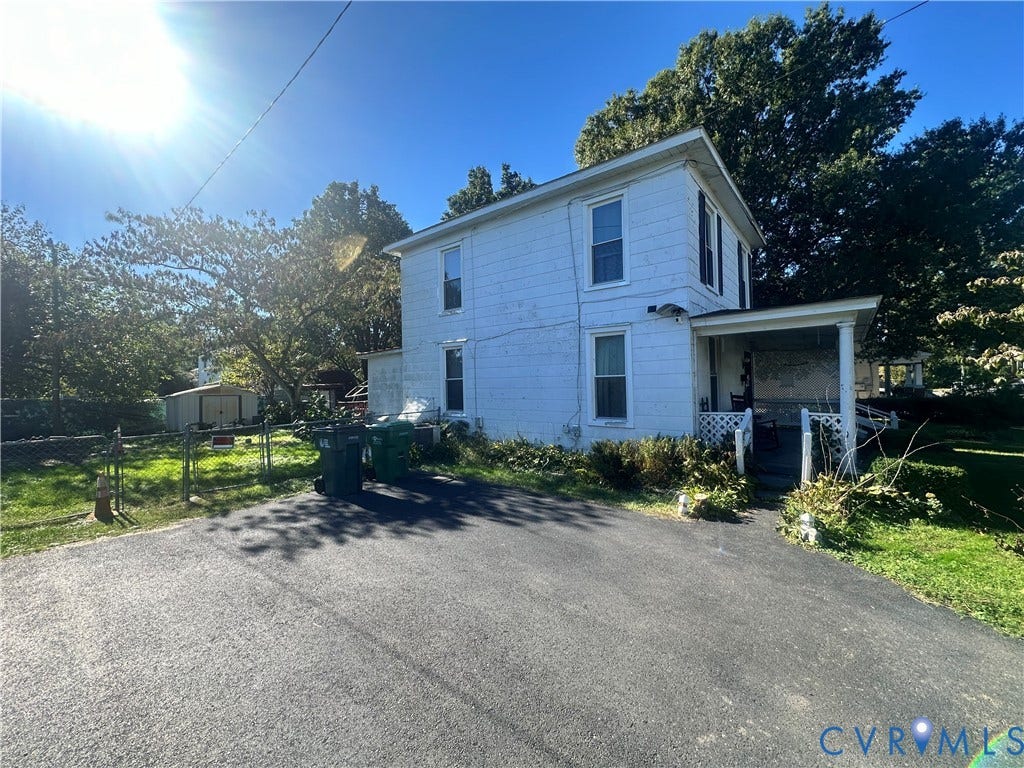 5 N Daisy Avenue, Henrico, VA 23075 Two-story white exterior featuring a front porch with supporting pillars, asphalt driveway, and detached storage structure