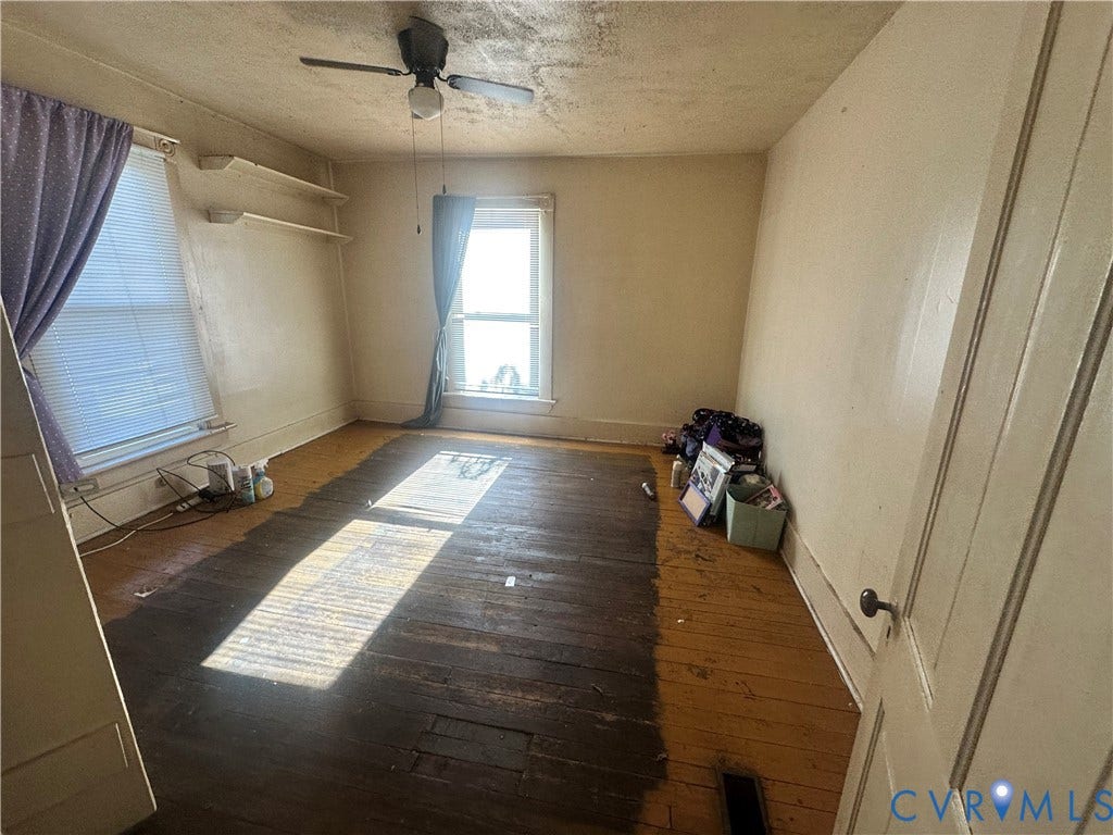 5 N Daisy Avenue, Henrico, VA 23075 Interior room featuring exposed original hardwood flooring, two double-hung windows, and a ceiling fan with integrated lighting