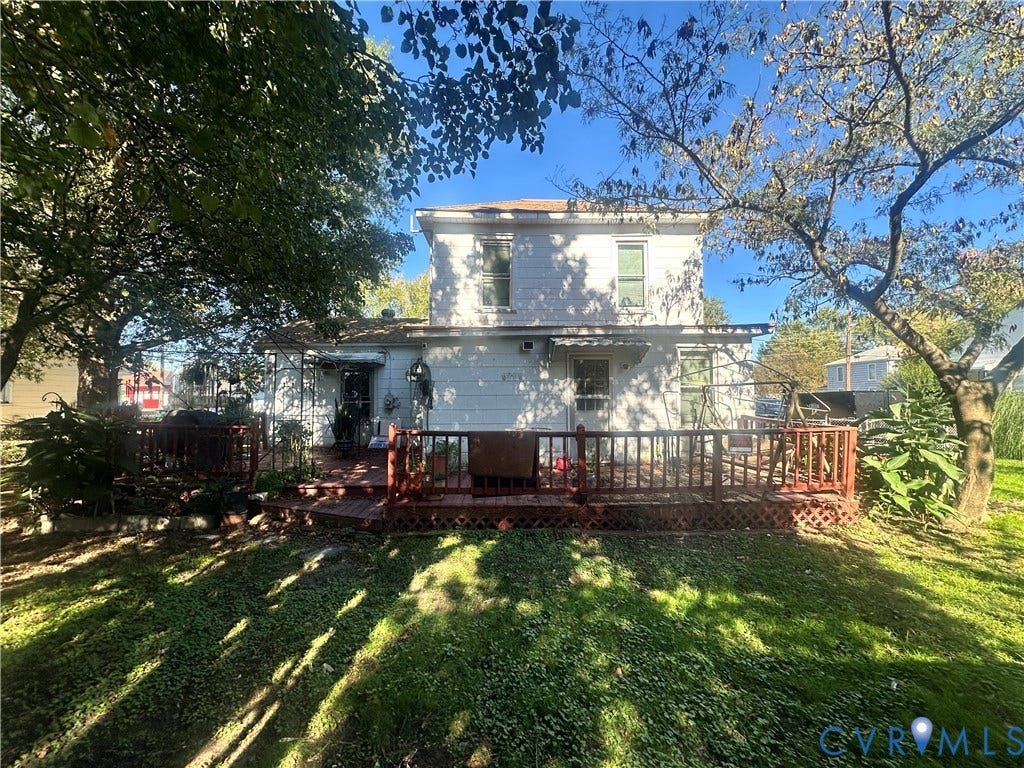 5 N Daisy Avenue, Henrico, VA 23075 Two-story residence with white siding featuring a rear wooden deck, lattice skirting, and mature landscaping