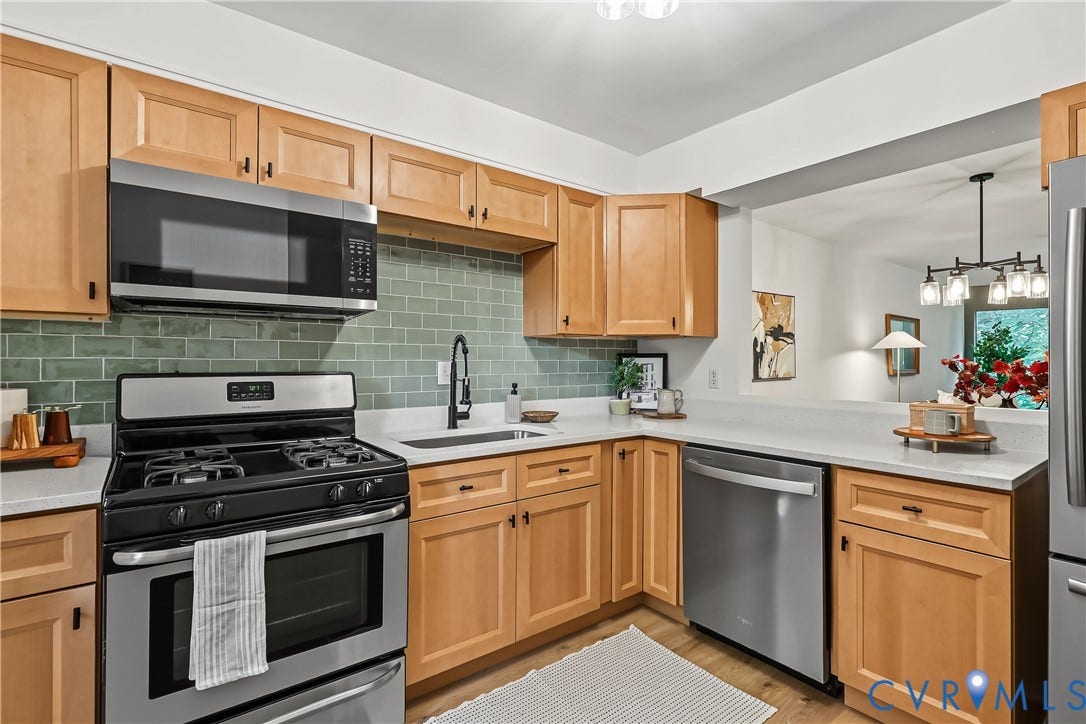 10272 Iron Mill Road, North Chesterfield, VA 23235 Kitchen featuring light wood cabinetry, stainless steel appliances, a green subway tile backsplash, solid-surface countertops, and a matte black gooseneck faucet
